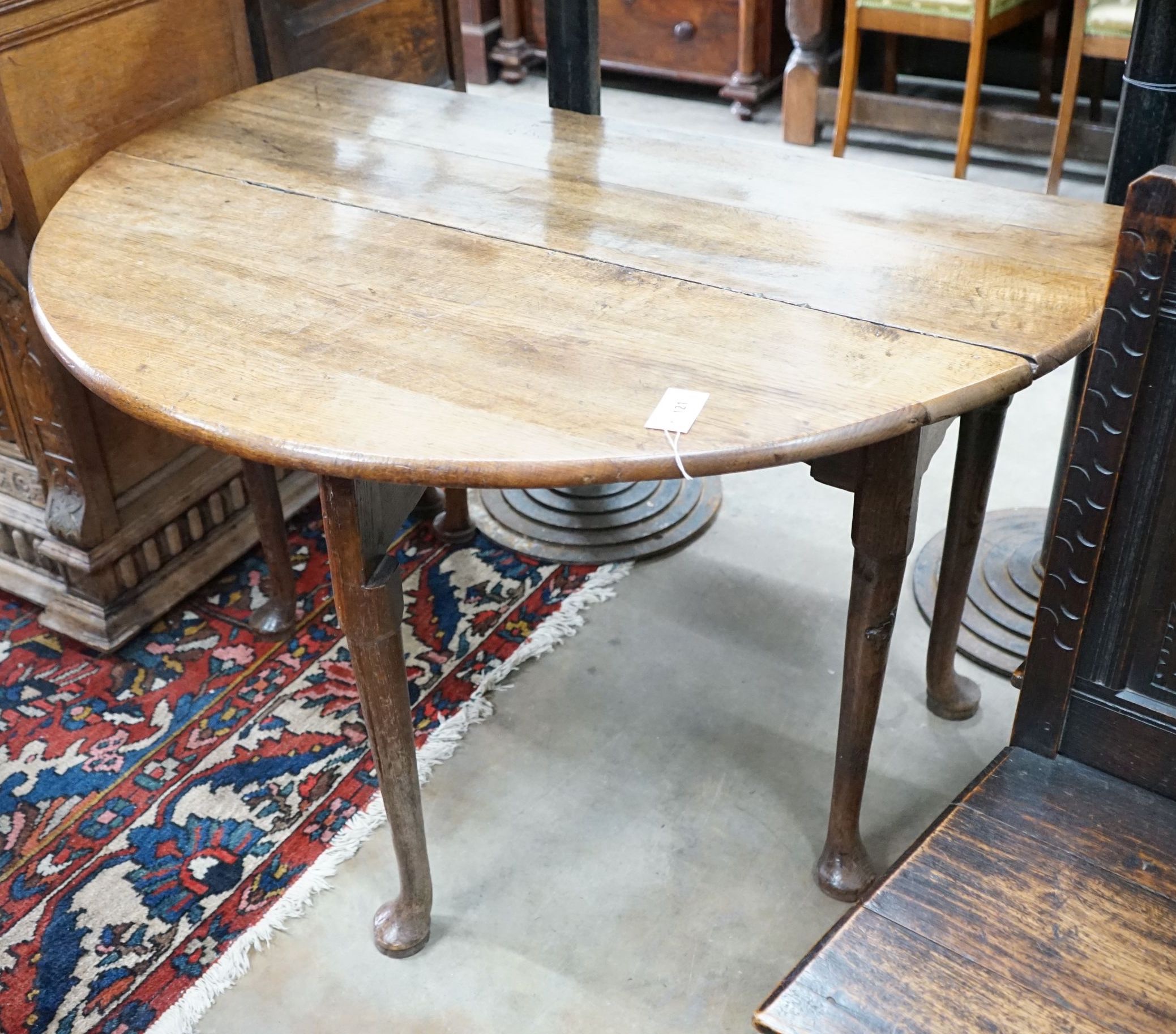 A George III provincial oak drop leaf pad foot dining table, length 120cm extended, width 120cm, height 72cm